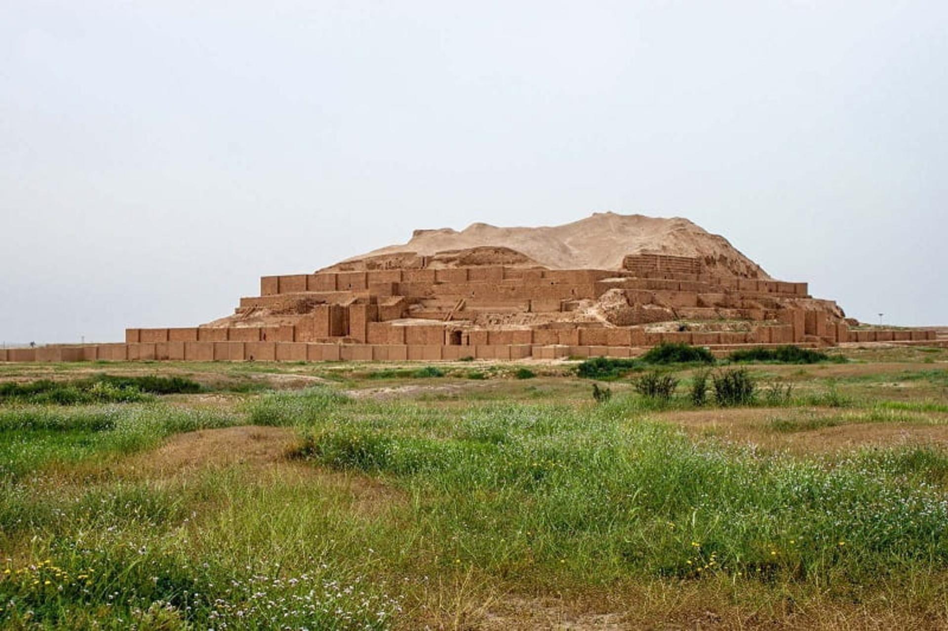 Stepped mud-brick tiers of the Chogha Zanbil ziggurat rising from the green Khuzestan plain