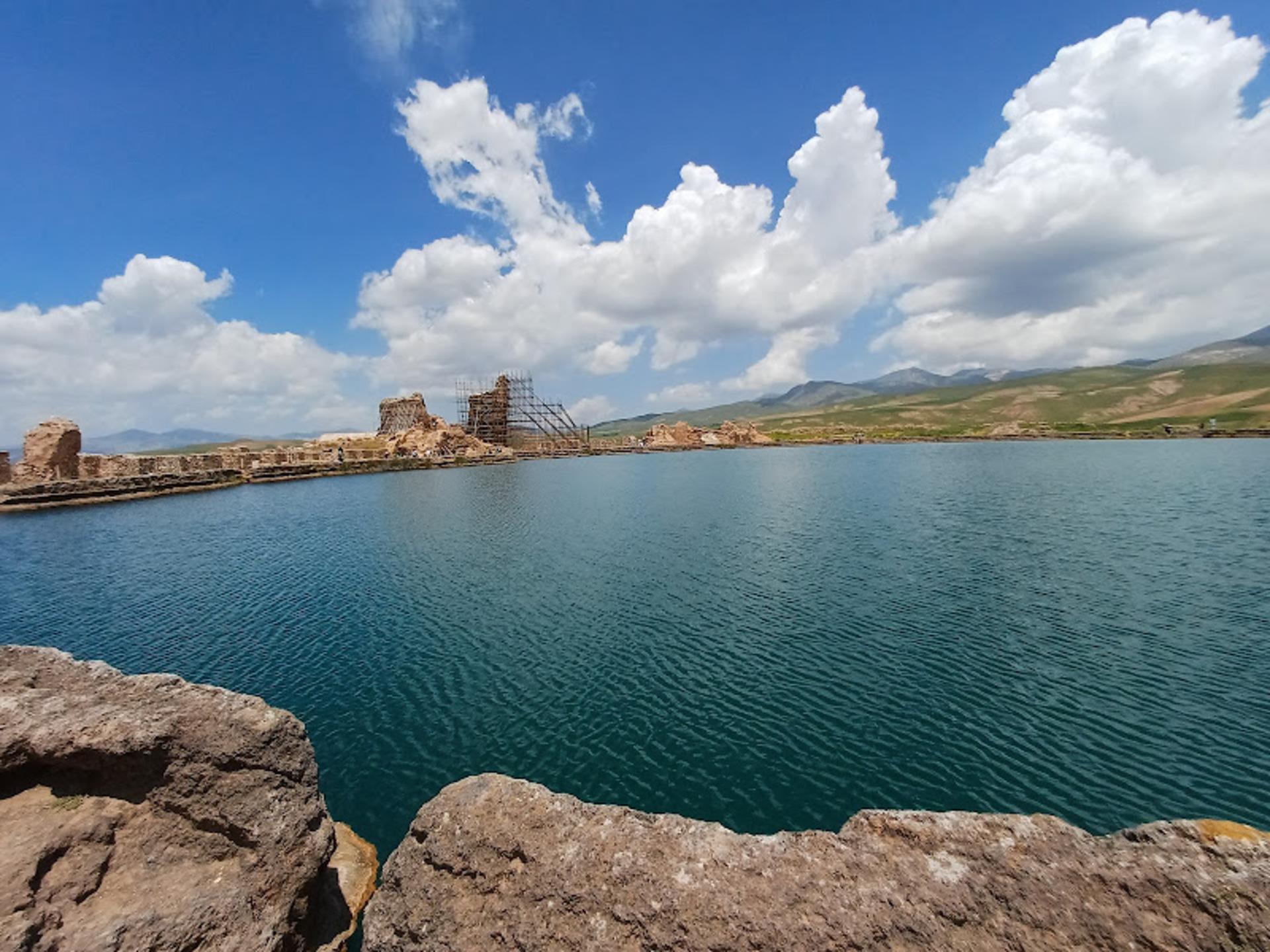 The lake at Takht-e Soleiman and the ruined fire temple on its shore, dry hills behind