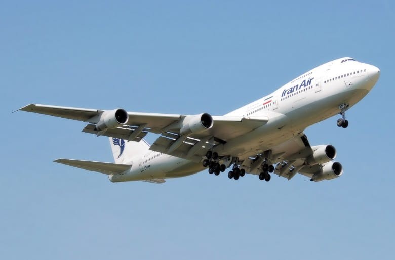 A commercial aircraft on a runway with mountains in the background