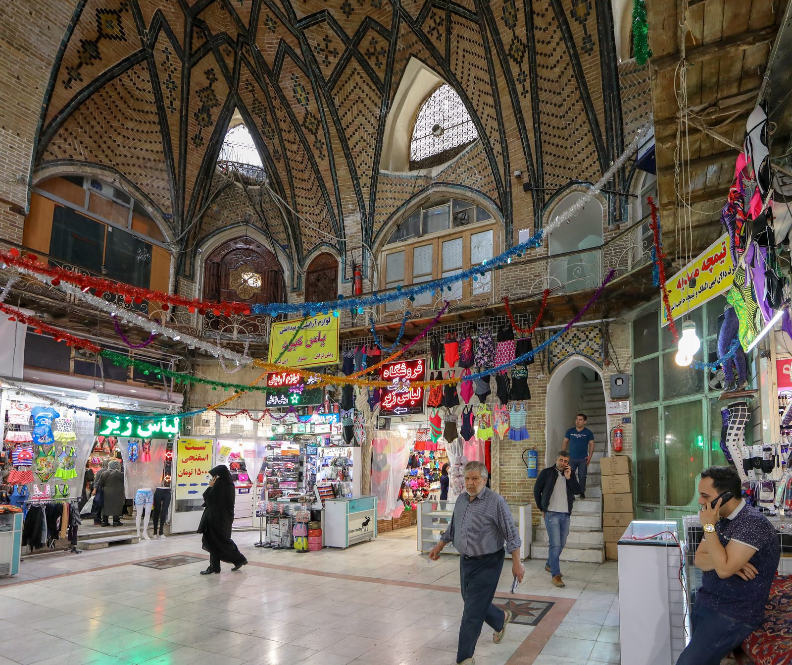 An ornate domed timcheh hall inside a traditional Iranian bazaar with intricate brickwork