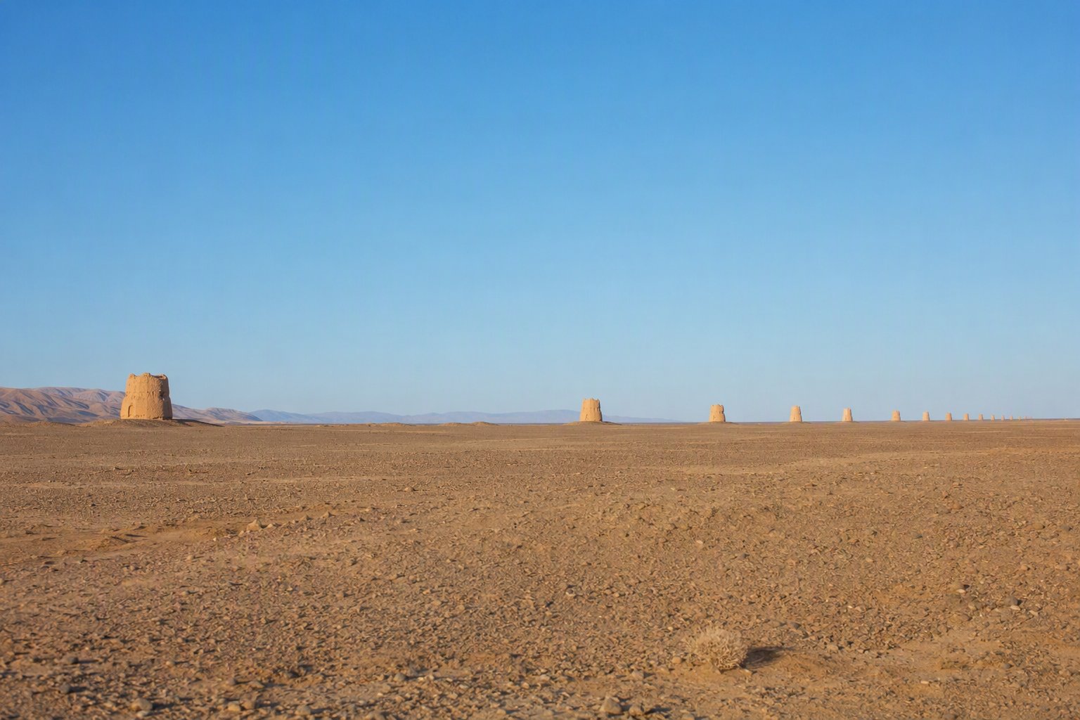 Line of mile towers stretching across the desert plain