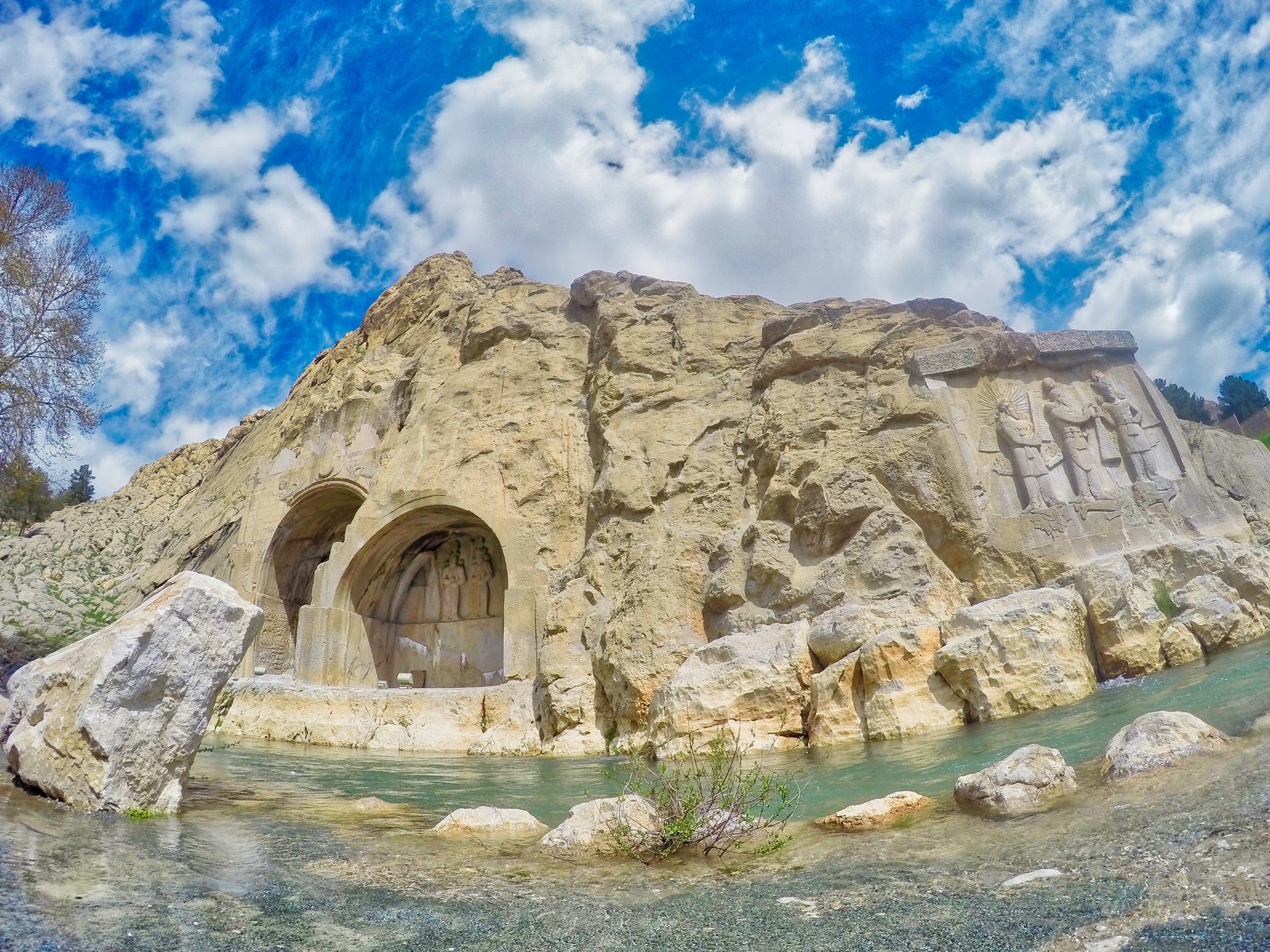 A detailed view of the Sassanid-era reliefs and arches at Taq-e Bostan