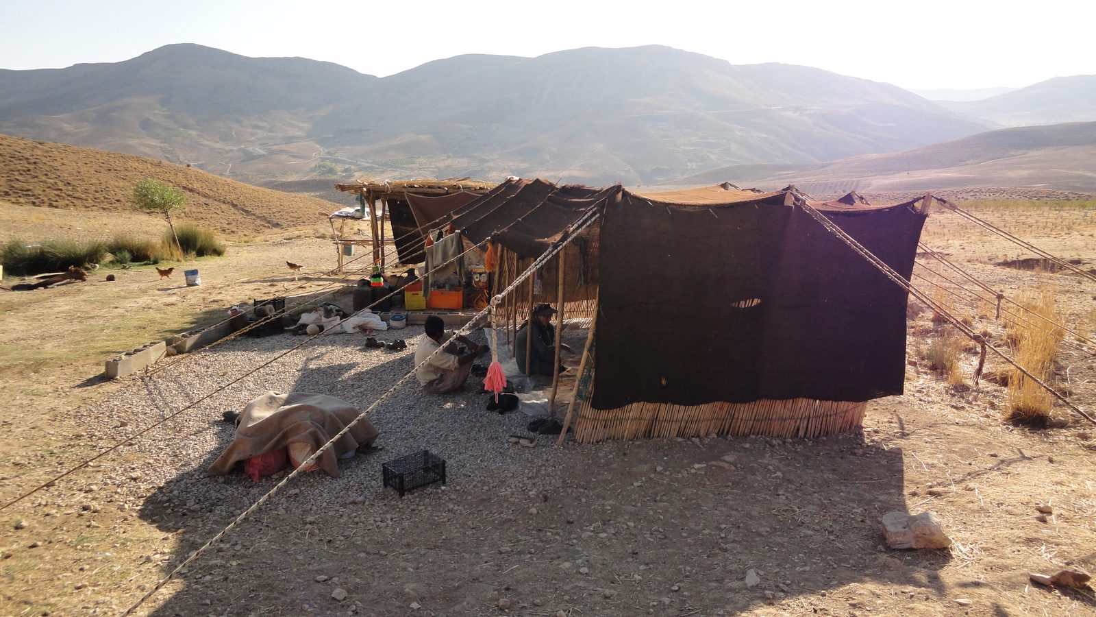Colorful nomadic carpet being woven on a horizontal ground loom by a Qashqai woman