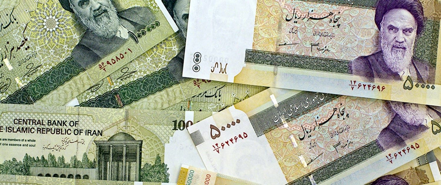 Currency exchange counter with rate boards and a clerk counting banknotes