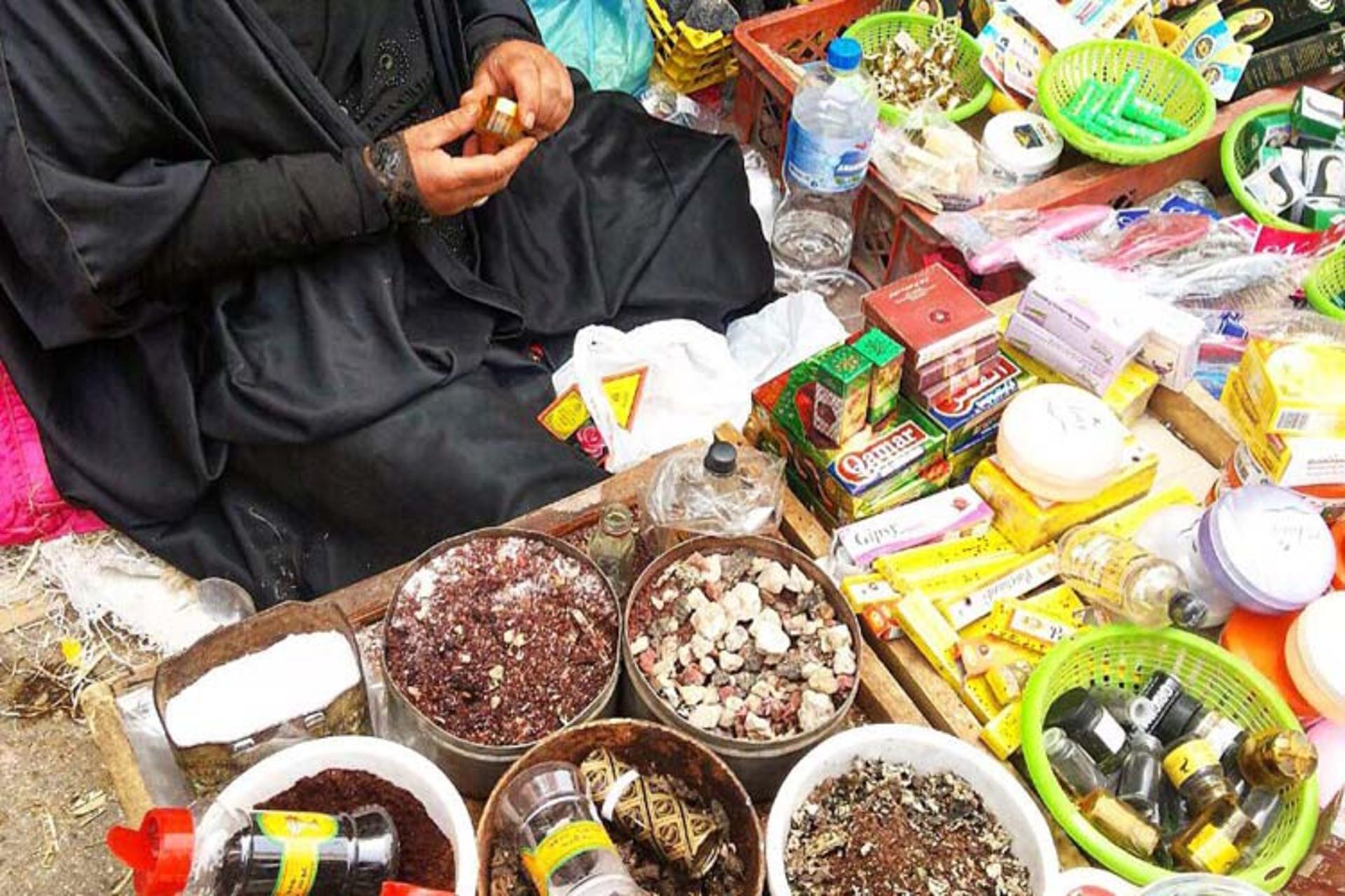A spice and herb seller at a floor stall in the bazaar