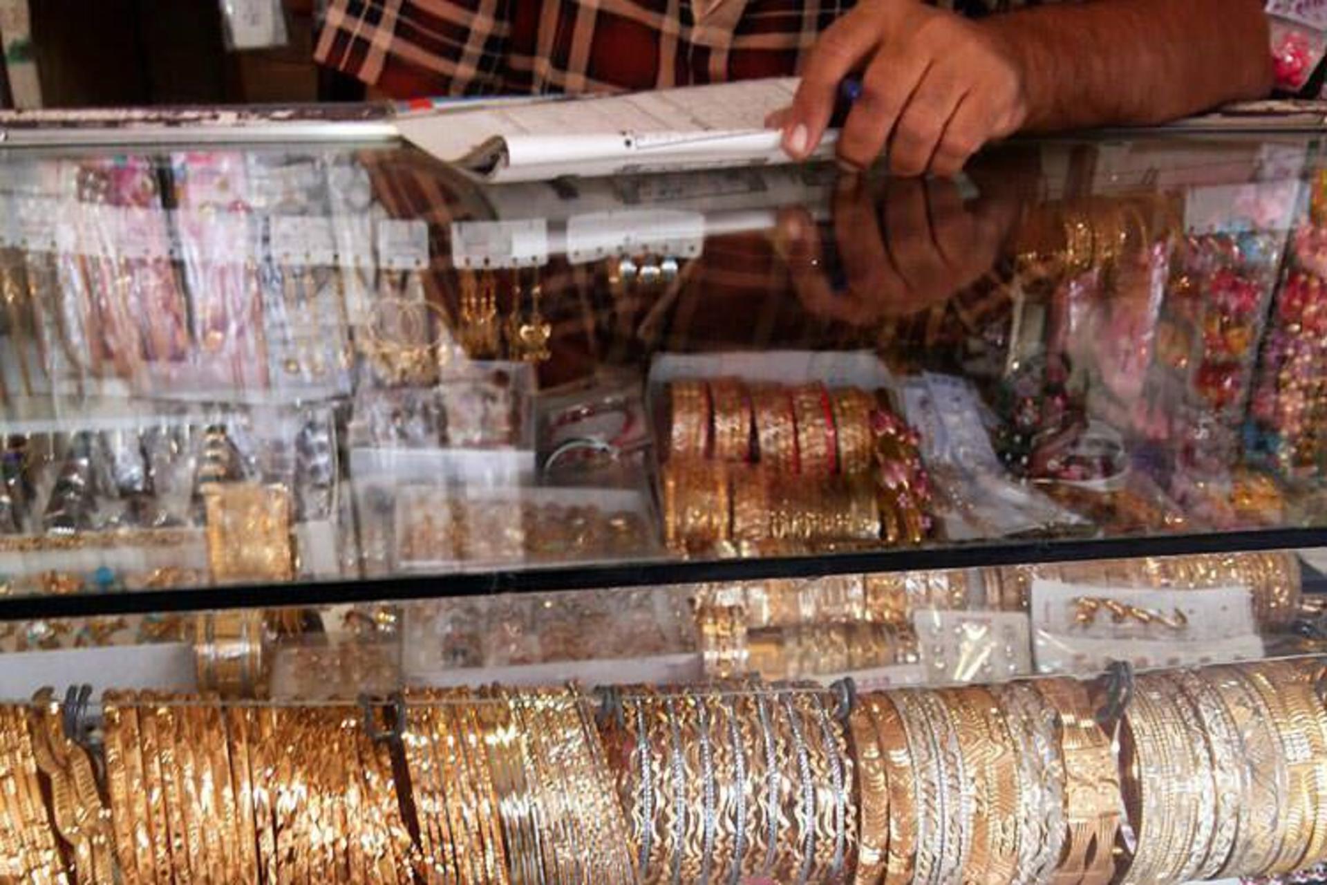 A jeweller's glass counter filled with gold and silver bangles