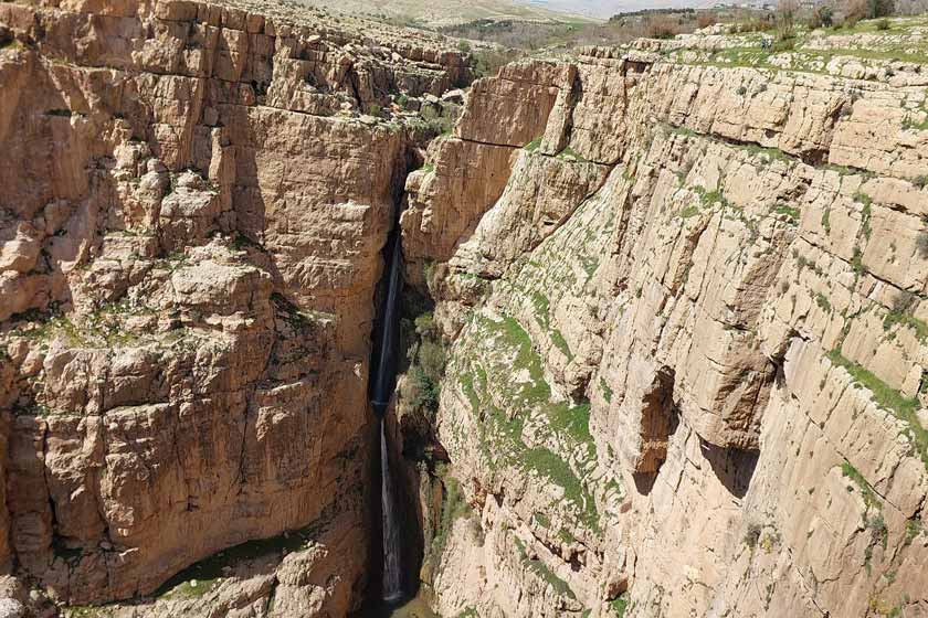 Aerial view of Piran Waterfall flowing through a green valley