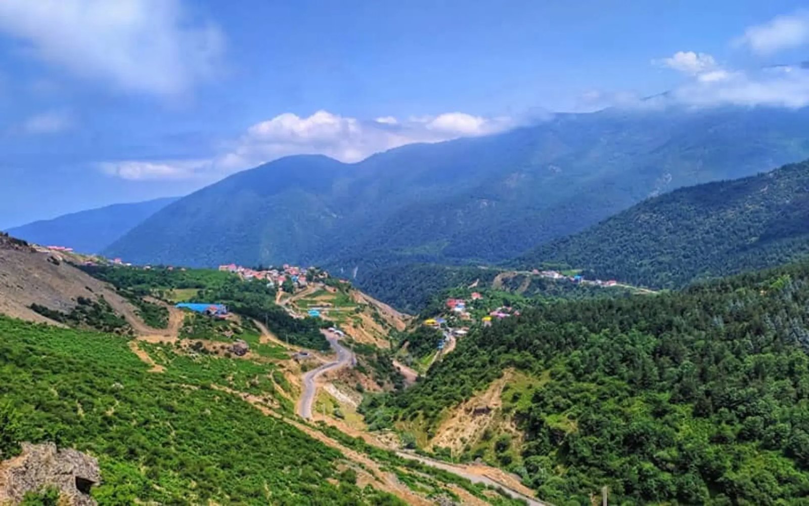 The hairpin Javaherdeh road climbing a green valley above Safarud