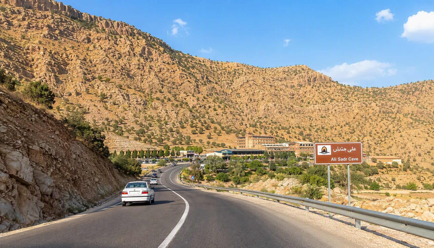 The paved road leading to Ali Sadr Cave tourist complex through the hills