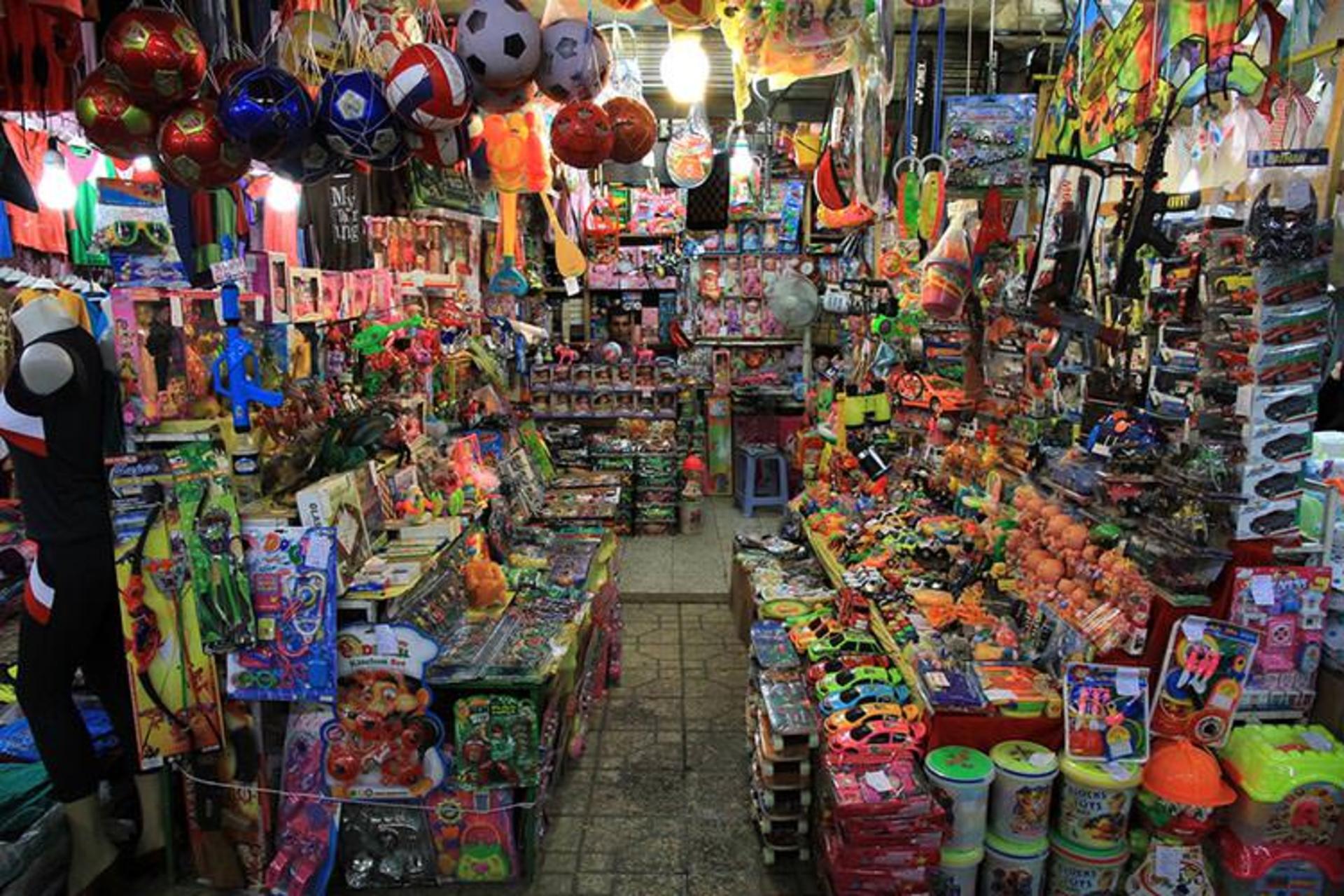 A crowded Astara shop aisle stacked with toys and household goods