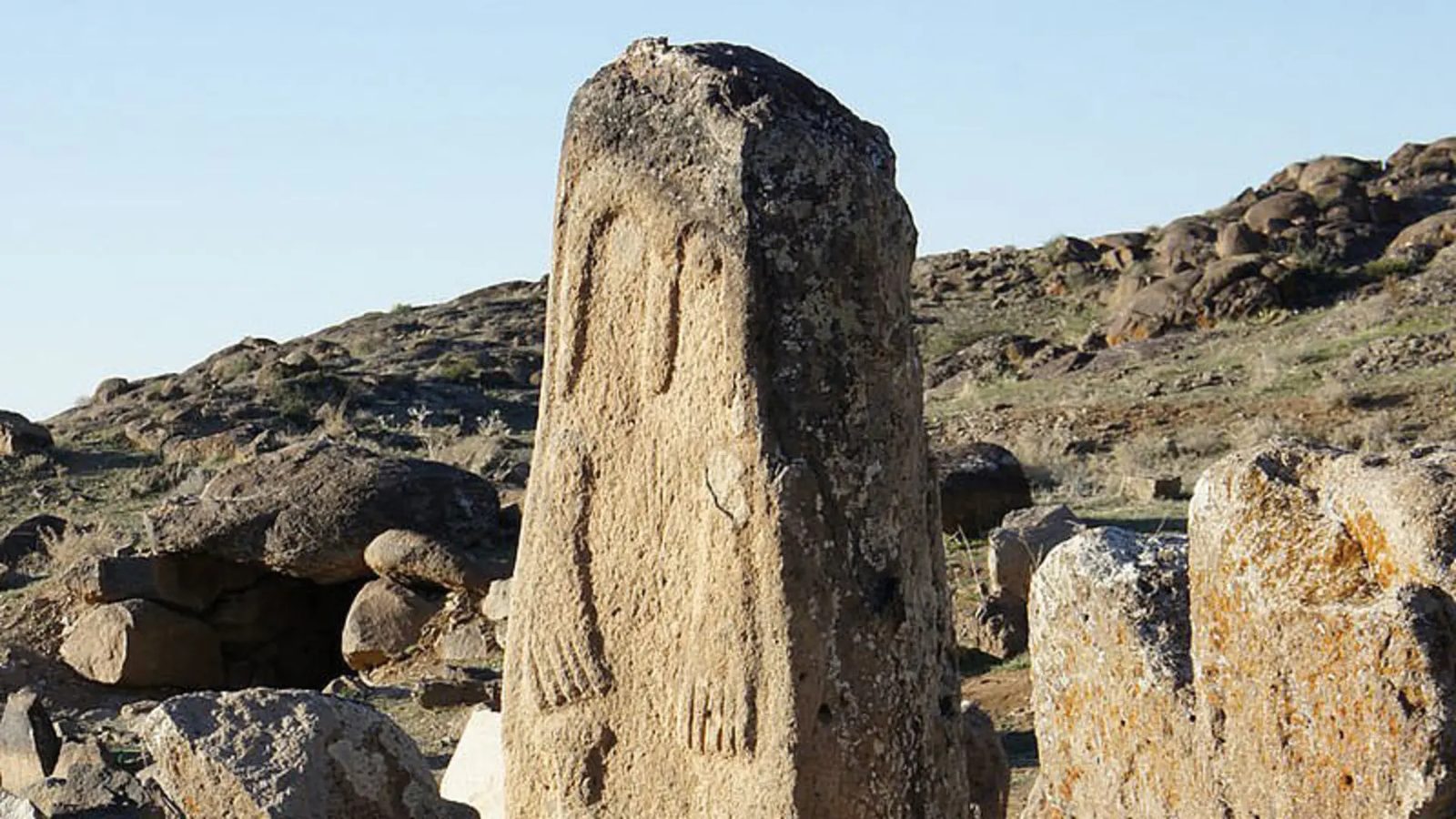 A carved standing megalith from Shiri (Yeri) city near Meshgin Shahr, its broad stone face incised with faceless human figures