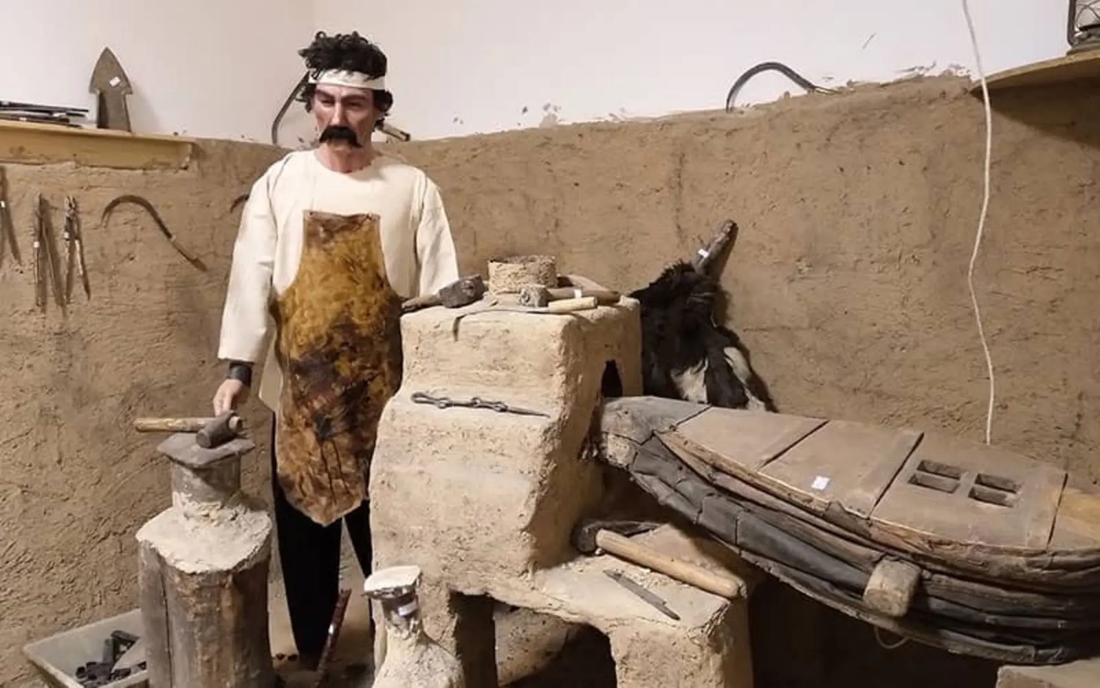 Museum diorama of a traditional blacksmith at a clay forge inside the Mofakham mansion