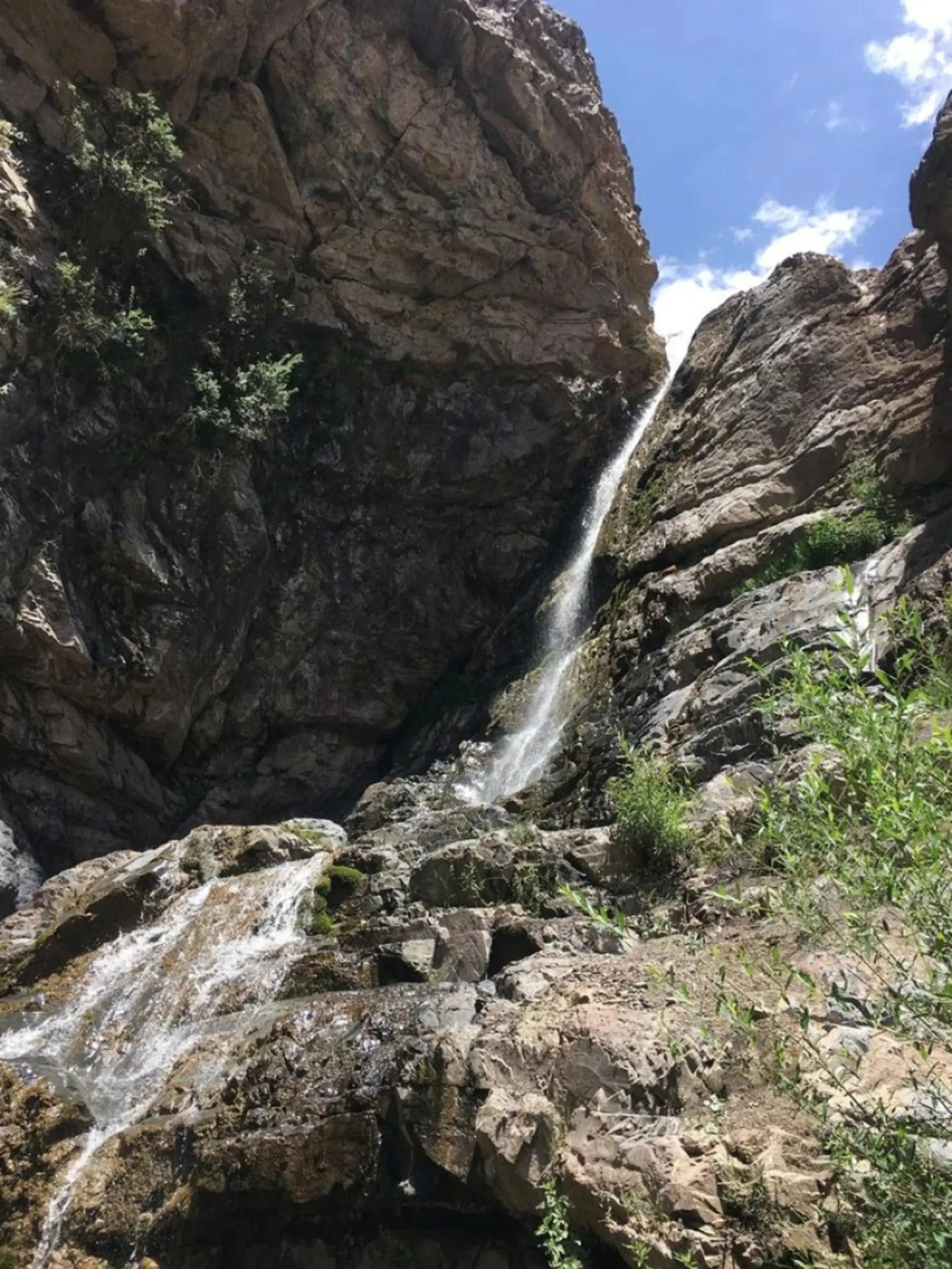 The Jangelak waterfall falling from a high ledge into the shade below