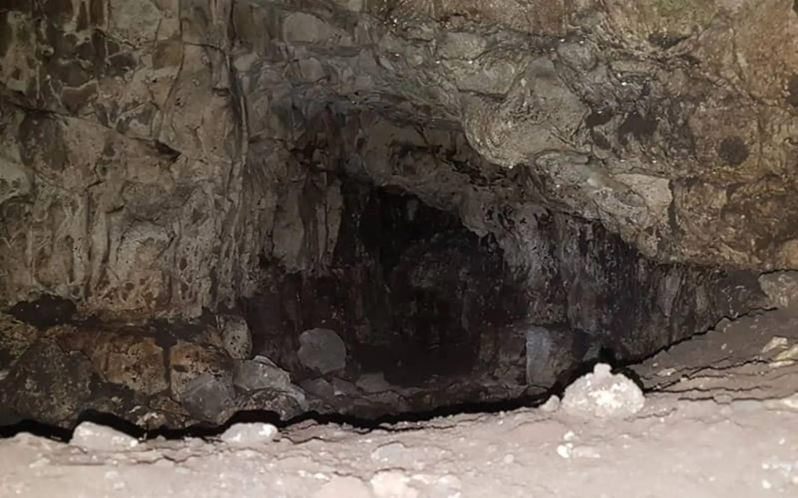 The rough rocky mouth of Komishan Cave with its wet stone floor
