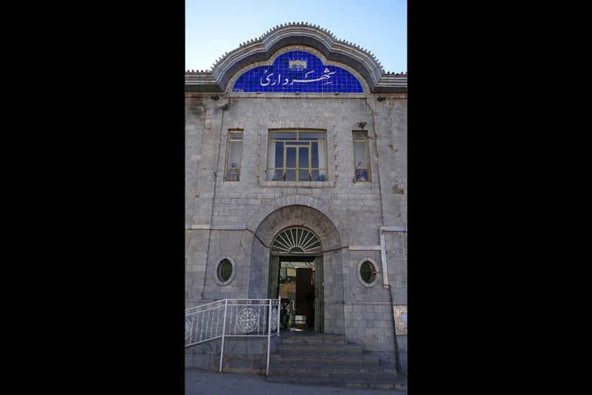 The Sanandaj Municipality Building, a grand stone structure with a clock tower and symmetrical facade