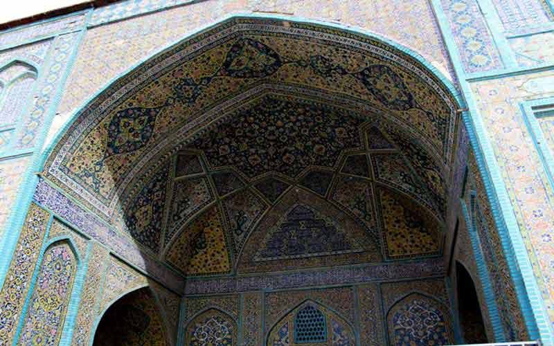Stone facade of the Sanandaj Grand Mosque with arched iwans and tilework details