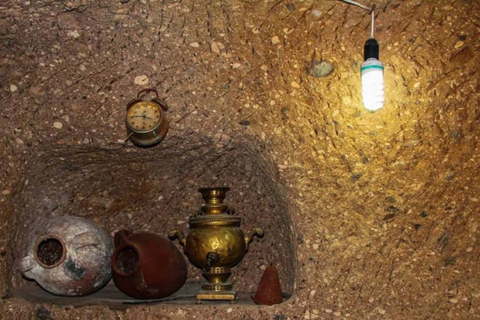 The mineral spring and stone lanes of Kandovan village, with visitors resting beside the water