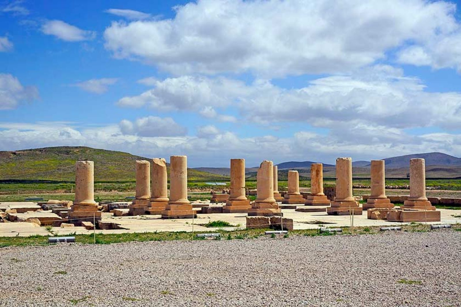 The Stone Tower and surrounding ruins at Pasargadae under a clear afternoon sky